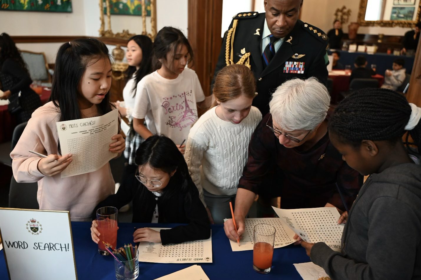 Mme Dumont et cinq élèves réunis autour d’une table font une activité de mots cachés.