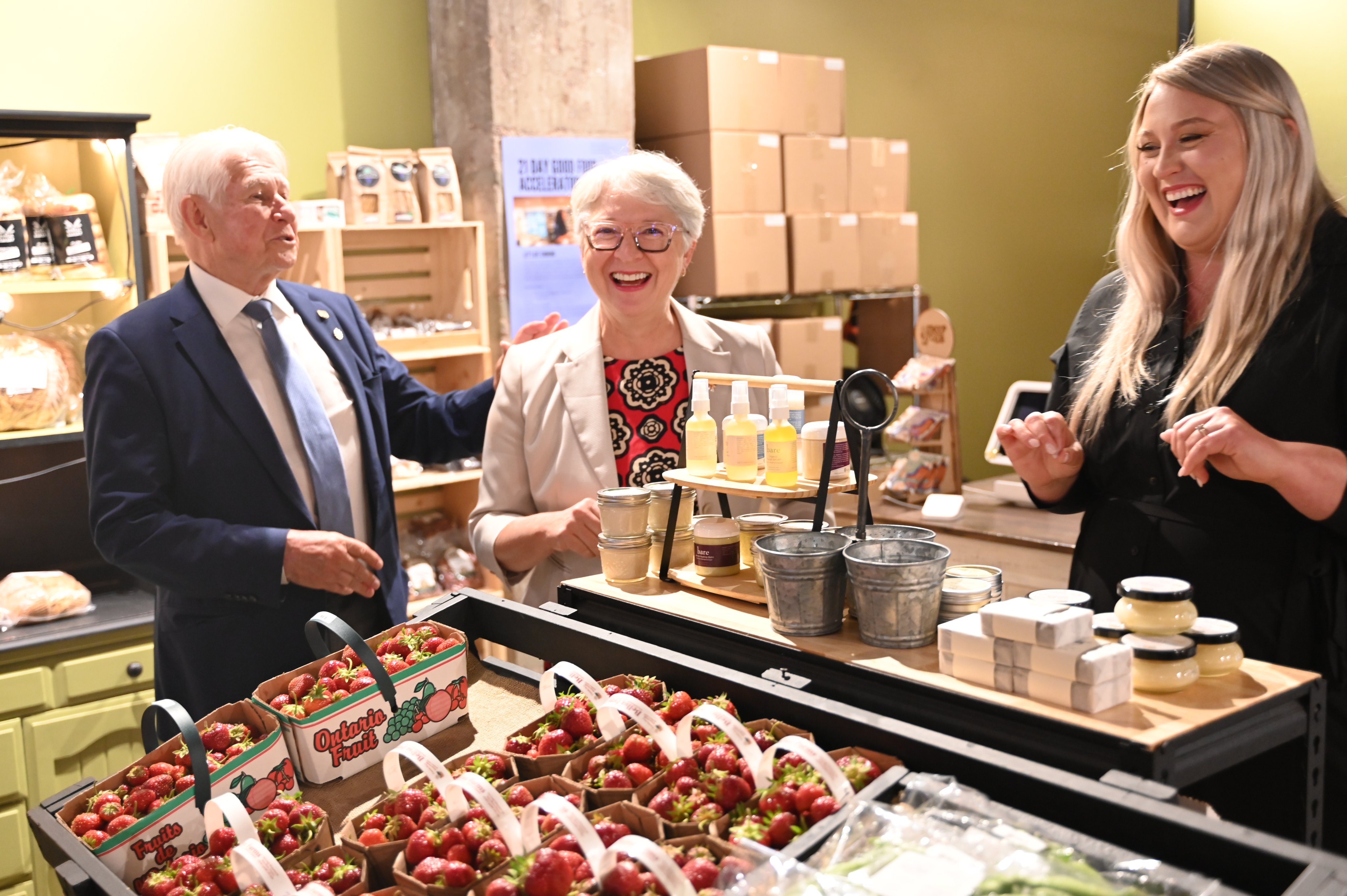 L'honorable Edith Dumont rit avec deux membres du Roots Community Food Centre
